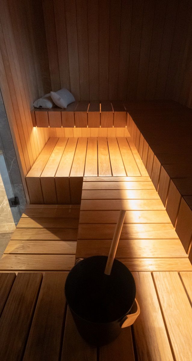 Una striscia LED da 7,2 W/m di tonalità calda in profilo di alluminio, montata sul lato inferiore della seduta della sauna.